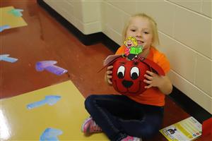 Girl with Clifford the Big Red Dog decorated pumpkin.